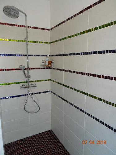 a bathroom with a shower with colorful stripes on the wall at Les Ecrins d'Aix-en-Provence in Aix-en-Provence