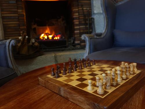 a chess board on a table in front of a fireplace at Grand Hôtel Bénodet Abbatiale Riviera Bretonne in Bénodet