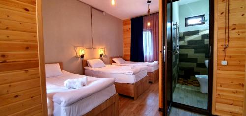 a room with three beds and a shower at Hotel Migu Yard in Stepantsminda