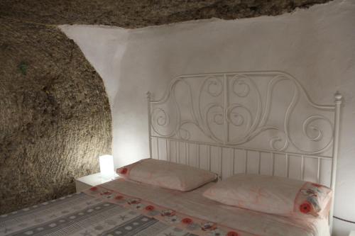 a bedroom with a white bed with flowers on it at Camera Nella Roccia in Tropea