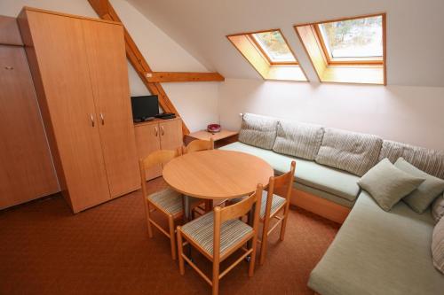 una pequeña sala de estar con mesa y sofá en BIKE & SKI Apartmány Lopušná dolina - Vysoké Tatry en Svit