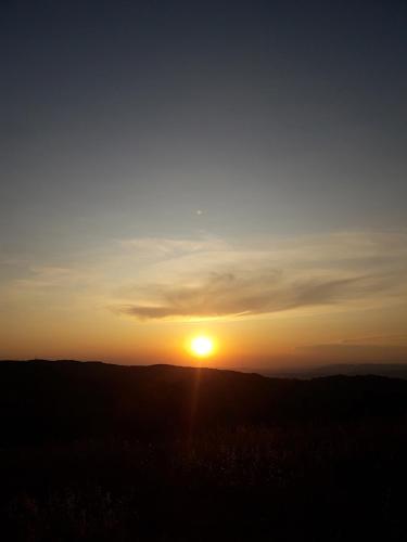 a sunset with the sun setting on the horizon at Poggio La Grognola in Cannara