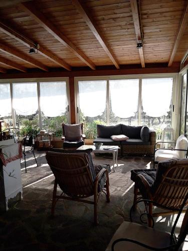 a living room with a couch and chairs and windows at Poggio La Grognola in Cannara