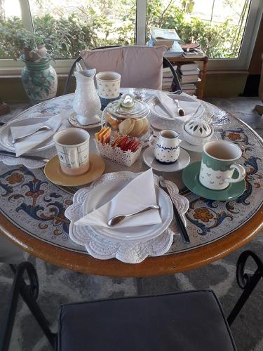 a table with cups and plates of food on it at Poggio La Grognola in Cannara