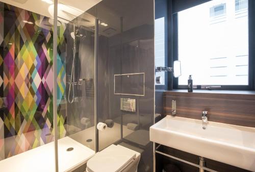 a bathroom with a sink and a shower and a toilet at Village Hotel Basingstoke in Basingstoke