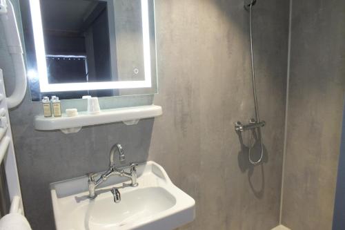 a bathroom with a sink and a shower at hotel du parc in Maclas