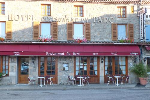 Maclasにあるhotel du parcの建物の前にテーブルと椅子があるホテル