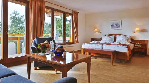 a hotel room with a bed and a coffee table at Schwarzwaldhotel Oberwiesenhof in Seewald