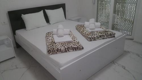 a bedroom with a white bed with two boxes on it at XXL APARTMENTS CiTY CENTAR in Bitola