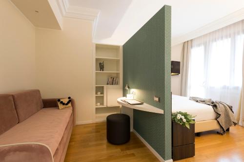 a bedroom with a bed and a couch and a desk at Elizabeth Lifestyle Hotel in Bologna