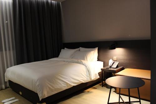 慶州的住宿－Rivertain Hotel Gyeongju，酒店客房配有一张床铺、一张桌子和一张书桌。