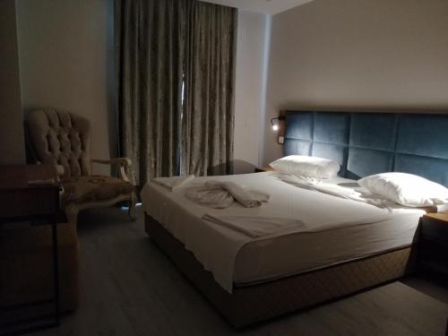 a bedroom with a large bed and a chair at Sirena Apart & SPA in Antalya