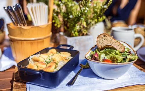 a table with a bowl of food and a bowl of salad at Appartements Liebe Heimat in Saalbach Hinterglemm