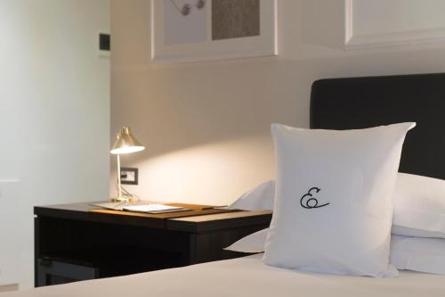 a bedroom with a bed with a desk and a white pillow at Elizabeth Lifestyle Hotel in Bologna