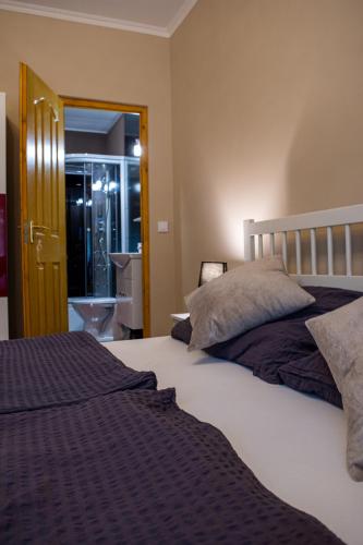 a bedroom with a large bed and a bathroom at Virág Vendégház in Makó