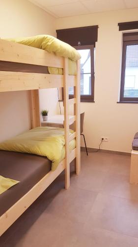 a bedroom with two bunk beds in a room at Vakantiewoning De Schuur Tienen in Tienen