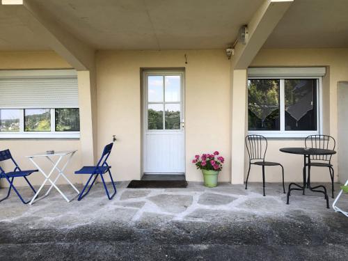 d'une terrasse avec des chaises, une table et une porte. dans l'établissement Les Agapanthes Site de Fondettes, à Fondettes