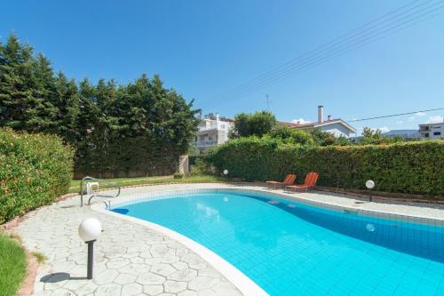 a swimming pool with blue water in a yard at Lovely Apartment Xylokastro 4th Floor in Xylokastron