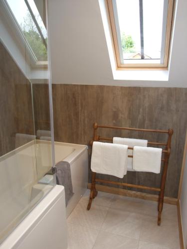 a bathroom with a bath tub and a window at The Barn in Redlynch
