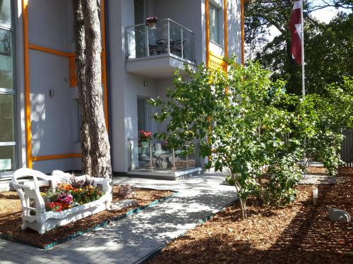 un edificio con balcón y flores en un patio en VILLA FLORANCE apartments with terraces & parking en Ventspils