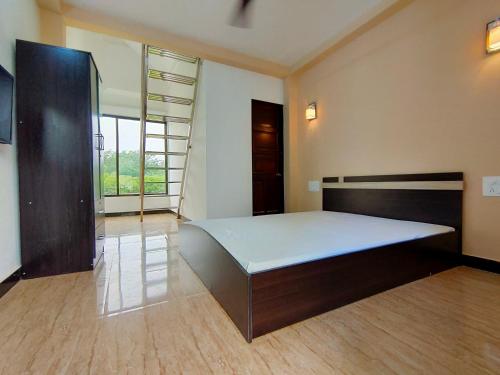 a bedroom with a large bed and a large window at Shobha Farmhouse in Kashid