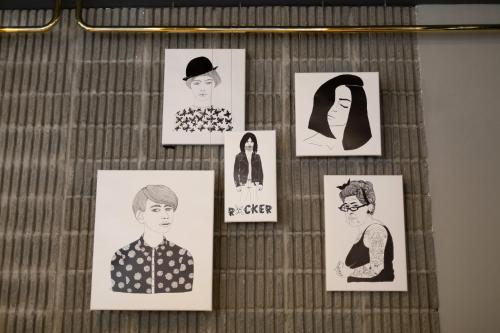 a display of drawings of people on a bed at Petit Palace Chueca in Madrid