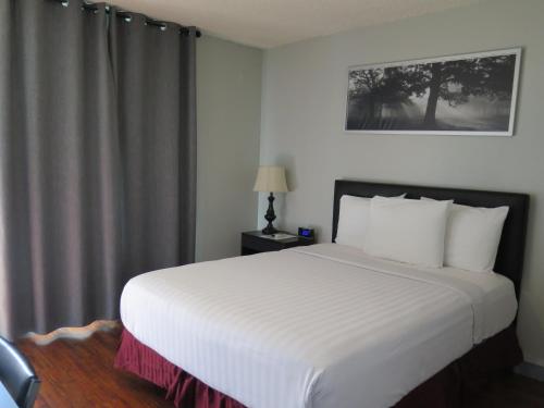 Un dormitorio con una gran cama blanca con ventana. en DTLA Hotel, en Los Ángeles