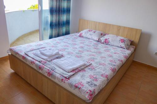 a bed with a wooden frame with a blanket and pillows at Alise in Bar