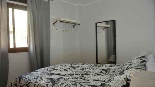 バジェ・グラン・レイにあるApt. El Molino 3Aのベッドルーム1室(ベッド1台、鏡、窓付)