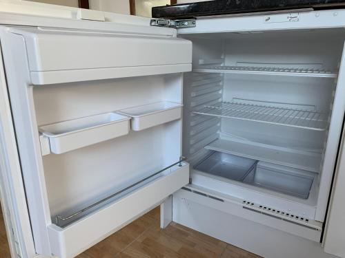 an empty refrigerator with its door open in a kitchen at Manchester Stay Hotel in Manchester