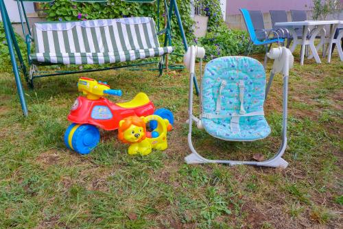 jouets pour enfants assis dans l'herbe à côté d'une chaise dans l'établissement Alise, à Bar