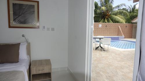 a bedroom with a bed and a view of a pool at Hotel Plein Soleil in Grand Anse