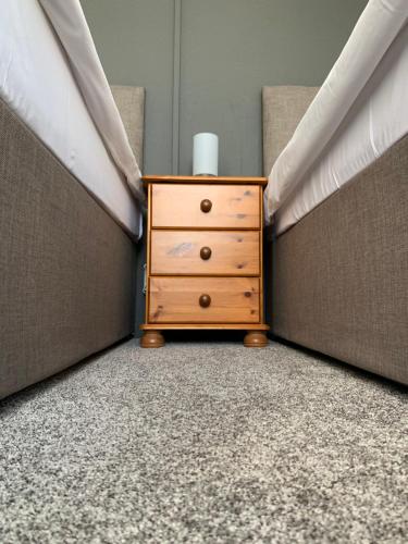 a wooden dresser in a corner of a bedroom at Manchester Stay Hotel - Free Parking in Manchester