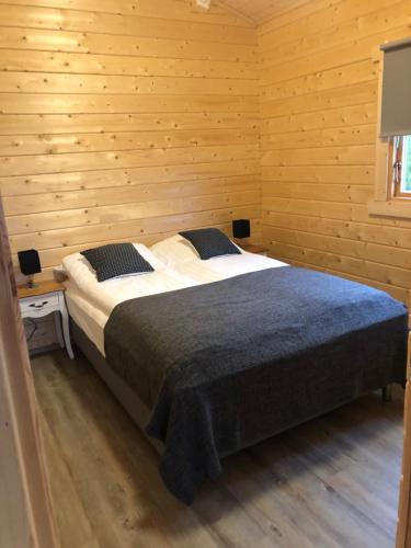 a bedroom with a bed in a wooden room at Miðsker 1 in Höfn