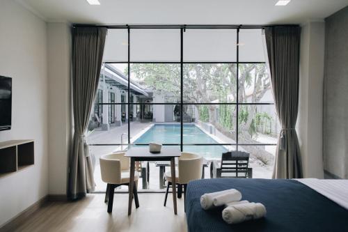 um quarto com uma cama, uma mesa e uma piscina em La Riva Boutique Hotel em Kamphaeng Phet