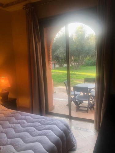 a bedroom with a bed and a view of a patio at la palmeraie village Appartement in Marrakech