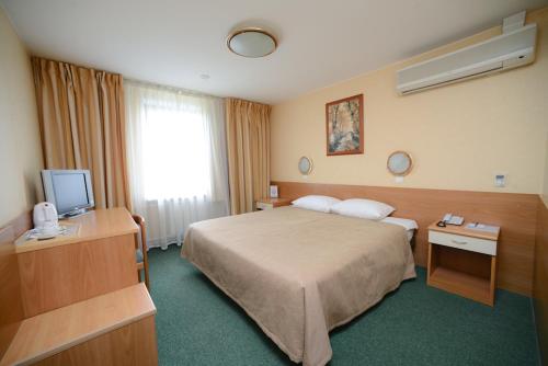 una camera d'albergo con letto e TV di Airhotel Domodedovo a Domodedovo