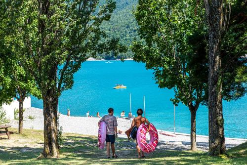 two men walking on the beach with their surfboards at L'Ecrin du Lac in Chorges