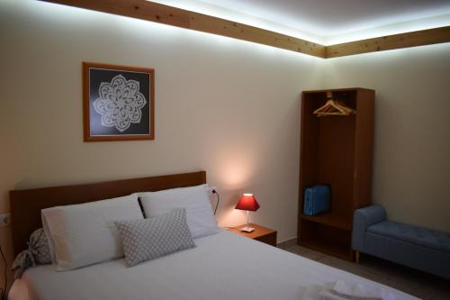 1 dormitorio con 1 cama y 1 silla azul en Casinha da Avó Jerónima RRAL 1519 en Madalena