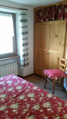 - une chambre avec un lit, une chaise et une fenêtre dans l'établissement CA' AURONIA, à Baceno
