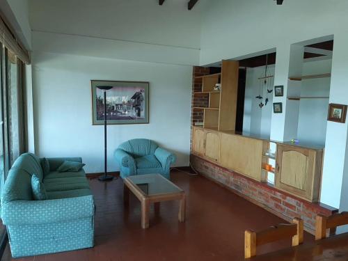 a living room with a couch and a table and a tv at Finca Paraíso in Calima