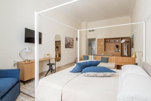 a bedroom with a large white bed with blue pillows at Palazzo Mulini in Monopoli