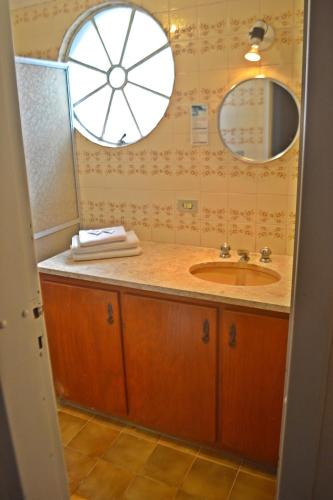 a bathroom with a sink and a mirror at Hotel Ampiezza in Curitiba