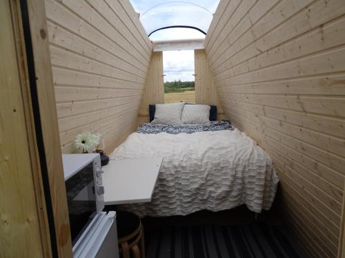 LaitilaにあるNiiralan Tila: Skylight Cabinのベッドと窓が備わる小さな客室です。