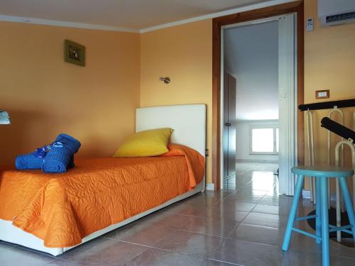 1 dormitorio con cama con almohada amarilla y taburete en The Yellow House IUN P3446, en Torre Grande