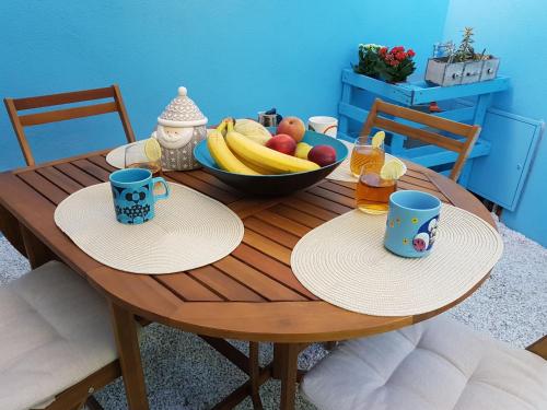 - une table en bois avec 2 tasses et un bol de fruits dans l'établissement The Yellow House IUN P3446, à Torre Grande