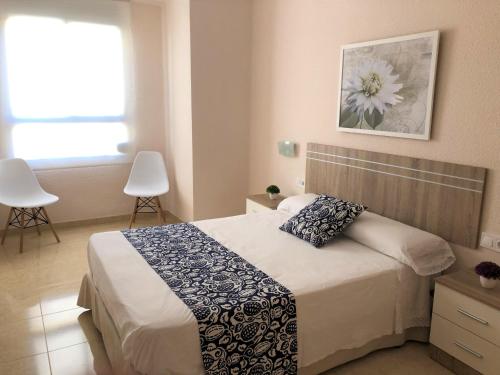 sypialnia z łóżkiem z obrazem kwiatowym na ścianie w obiekcie Valencia Gold Beach w Walencji