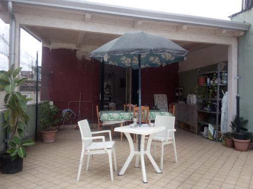 una mesa y sillas con una sombrilla en el patio en The Sunny Place, en Nápoles
