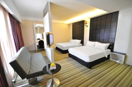 a hotel room with two beds and a television at The Sterling Boutique Hotel Melaka in Melaka