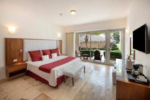 a hotel room with a large bed and a television at Viva Dominicus Beach by Wyndham, A Trademark All Inclusive in Bayahibe
